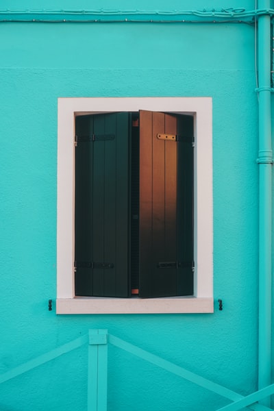 粉色混凝土墙上的蓝色木窗